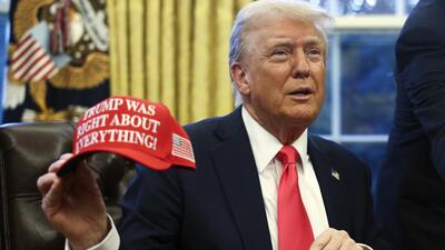 President Donald Trump holds up a hat as he talks with reporters in the Oval Office at the White House in Washington. (AP) President Donald Trump holds up a hat as he talks with reporters in the Oval Office at the White House in Washington. (AP)