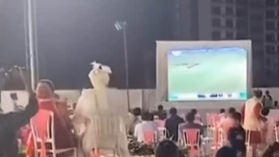 In the video, the bride and groom can be seen seated on two chairs on the chairs facing a large screen. (X/@JaikyYadav16)