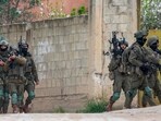 An Israeli soldier aims his rifle during a raid. An Israeli soldier aims his rifle during a raid.