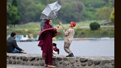 A woman and boy share a moment of laughter while trying to control a flipped umbrella amid windy and rainy weather at Sukhna Lake in Chandigarh on Thursday. (Ravi Kumar/HT) A woman and boy share a moment of laughter while trying to control a flipped umbrella amid windy and rainy weather at Sukhna Lake in Chandigarh on Thursday. (Ravi Kumar/HT)