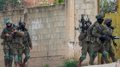 An Israeli soldier aims his rifle during a raid. (AFP) An Israeli soldier aims his rifle during a raid. (AFP)