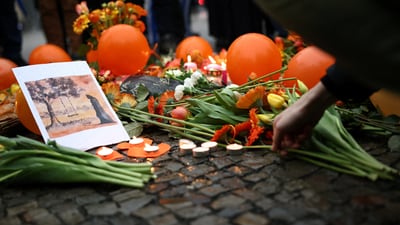 A person places a flower next to orange balloons as Israeli supporters gather to commemorate the Bibas family and "against Hamas terror". (REUTERS)