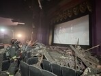 A firefighter looks at the screen, standing amid the mess caused by a ceiling collapse during the screening of Captain America: Brave New World. 