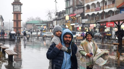 People take a stroll amid fresh snowfall at Lal Chowk in Srinagar on Thursday. (Basit Zargar) People take a stroll amid fresh snowfall at Lal Chowk in Srinagar on Thursday. (Basit Zargar)