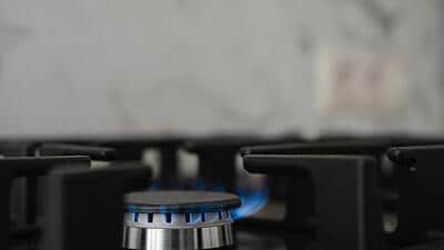 Modern kitchen stove, natural gas burns with a blue flame. Household gas consumption. Close-up, selective focus Modern kitchen stove, natural gas burns with a blue flame. Household gas consumption. Close-up, selective focus
