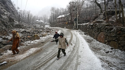 People walk through snowfall on the outskirts of Srinagar on Thursday. Incessant rain continued to lash wide parts of Jammu for the third consecutive day, leading to the tragic death of a woman and her son, while 12 others were rescued from swollen water bodies. (HT Photo/ Waseem Andrabi) People walk through snowfall on the outskirts of Srinagar on Thursday. Incessant rain continued to lash wide parts of Jammu for the third consecutive day, leading to the tragic death of a woman and her son, while 12 others were rescued from swollen water bodies. (HT Photo/ Waseem Andrabi)