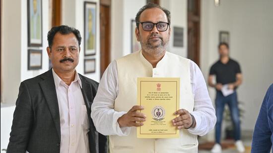Delhi health minister Pankaj Singh with the CAG report on health care services, at the Delhi legislative assembly on Friday. (RAJ K RAJ /HT PHOTO)
