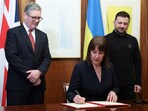 Britain's Chancellor of the Exchequer Rachel Reeves, front, signs a document of defence lend for Ukraine on the day she holds a video conference meeting with Ukraine's Finance Minister Sergii Marchenko, as British Prime Minister Keir Starmer, left, and Ukrainian President Volodymyr Zelenskiyy, right, stand in London, England, March 1, 2025. 