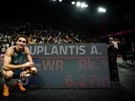 Swedish athlete Armand Duplantis poses next to a screen displaying his record as he celebrates after beating his own world record at 6.27m.