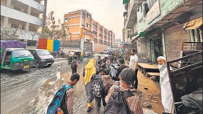 Children cross the waterlogged street to reach their schools. (HT Photo) Children cross the waterlogged street to reach their schools. (HT Photo)