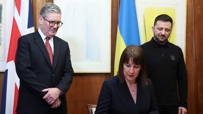 Britain's Chancellor of the Exchequer Rachel Reeves, front, signs a document of defence lend for Ukraine on the day she holds a video conference meeting with Ukraine's Finance Minister Sergii Marchenko, as British Prime Minister Keir Starmer, left, and Ukrainian President Volodymyr Zelenskiyy, right, stand in London. (AP) Britain's Chancellor of the Exchequer Rachel Reeves, front, signs a document of defence lend for Ukraine on the day she holds a video conference meeting with Ukraine's Finance Minister Sergii Marchenko, as British Prime Minister Keir Starmer, left, and Ukrainian President Volodymyr Zelenskiyy, right, stand in London. (AP)