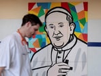 A man walks near a painting depicting Pope Francis at the Gemelli Hospital, where he is admitted for treatment, in Rome, Italy, March 3, 2025.