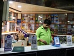 QR codes of digital payment firms PhonePe and Paytm are seen on the counter of a grocery store in Ahmedabad.