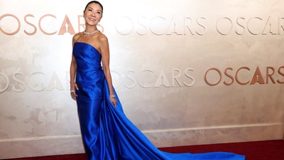 Michelle Yeoh poses during the Oscars arrivals. The Oscar-winning actor wore a dazzling blue strapless gown featuring a long train on the back.&nbsp; (REUTERS)