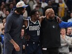 Dallas Mavericks' Anthony Davis, left, and a staff member, right, assist Kyrie Irving (11) off the court after he suffered an unknown injury in the first half of an NBA basketball game against the Sacramento Kings in Dallas, Monday, March 3, 2025. Dallas Mavericks' Anthony Davis, left, and a staff member, right, assist Kyrie Irving (11) off the court after he suffered an unknown injury in the first half of an NBA basketball game against the Sacramento Kings in Dallas, Monday, March 3, 2025.