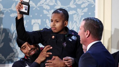 Cancer survivor Devarjaye "DJ" Daniel gestures as he is made an honorary Secret Service agent on the day of U.S. President Donald Trump's speech to a joint session of Congress, in the House Chamber of the Capitol in Washington, DC. (REUTERS)