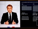 This photograph taken on March 5, 2025, shows a television screen broadcasting France's President Emmanuel Macron (L) addressing a live interview next to a graph showing the projected evolution of the Russian army on French TV at the Elysee Presidential Palace in Paris. 