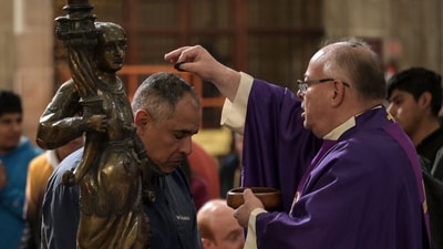 A Catholic priest applies ash on a faithful attending the Ash Wednesday mass which marks the beginning of a 40-day period of Lent that culminates in Easter Sunday at Mexico City Metropolitan Cathedral on March 5, 2025. (Photo by Yuri CORTEZ / AFP) (AFP) A Catholic priest applies ash on a faithful attending the Ash Wednesday mass which marks the beginning of a 40-day period of Lent that culminates in Easter Sunday at Mexico City Metropolitan Cathedral on March 5, 2025. (Photo by Yuri CORTEZ / AFP) (AFP)