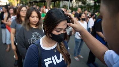 A seminarian applies ash to a woman's forehead on the observance of Ash Wednesday at a church ground in Manila on March 5, 2025. The 40-day period of Lent begins on Ash Wednesday, with Catholics around the world observing the season which culminates in Easter Sunday. (Photo by Ted ALJIBE / AFP) (AFP) A seminarian applies ash to a woman's forehead on the observance of Ash Wednesday at a church ground in Manila on March 5, 2025. The 40-day period of Lent begins on Ash Wednesday, with Catholics around the world observing the season which culminates in Easter Sunday. (Photo by Ted ALJIBE / AFP) (AFP)