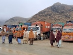 People stand next to parked trucks loaded with supplies at the Torkham border crossing following the closure of the border crossing between Pakistan and Afghanistan (File)