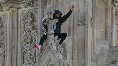 A protester holding a Palestinian flag gestures from the side of the Elizabeth Tower, commonly known by the name of the clock's bell "Big Ben", at the Palace of Westminster. (AFP)