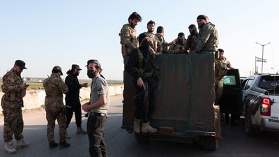 Syrian army personnel gather as they head towards Latakia to join the fight against the fighters linked to Syria's ousted leader Bashar al-Assad, in Aleppo, Syria. (REUTERS)