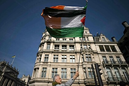 People gather in the street to support a protester holding a Palestinian flag who has climbed the side of the Elizabeth Tower. (AFP)