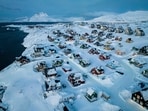 Houses covered by snow are seen on the coast of a sea inlet of Nuuk, Greenland.