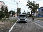 A Ukrainian serviceman patrols a street next to buildings damaged during recent fighting between Ukrainian and Russian forces in the Ukrainian-controlled town of Sudzha in Russia's Kursk region in August 2024.