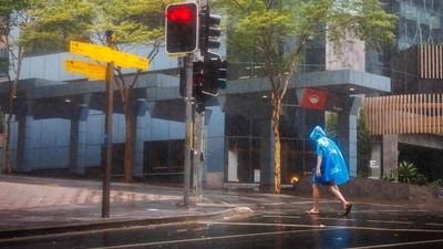A man walks through the Central Business District (CBD) area of Brisbane on March 8, 2025, as cyclone Alfred crossed the southeast Queensland coast. Cyclone Alfred weakened into a tropical low on March 8 but still threatened to unleash major floods on swollen rivers as it approached the rain and wind-lashed eastern coast of Australia. (AFP) A man walks through the Central Business District (CBD) area of Brisbane on March 8, 2025, as cyclone Alfred crossed the southeast Queensland coast. Cyclone Alfred weakened into a tropical low on March 8 but still threatened to unleash major floods on swollen rivers as it approached the rain and wind-lashed eastern coast of Australia. (AFP)