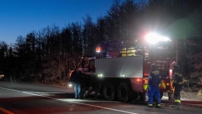 Firemen stand on the road side near Francis S. Gabreski Airport on March 8, 2025 in Westhampton, New York. Strong winds fueled multiple brush fires on New York's Long Island, closing roads and reportedly burning structures. (Photo by David Dee Delgado / GETTY IMAGES NORTH AMERICA / Getty Images via AFP) (Getty Images via AFP) Firemen stand on the road side near Francis S. Gabreski Airport on March 8, 2025 in Westhampton, New York. Strong winds fueled multiple brush fires on New York's Long Island, closing roads and reportedly burning structures. (Photo by David Dee Delgado / GETTY IMAGES NORTH AMERICA / Getty Images via AFP) (Getty Images via AFP)