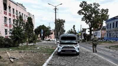 A Ukrainian serviceman patrols a street next to buildings damaged during recent fighting between Ukrainian and Russian forces in the Ukrainian-controlled town of Sudzha in Russia's Kursk region in August 2024. (Reuters)
