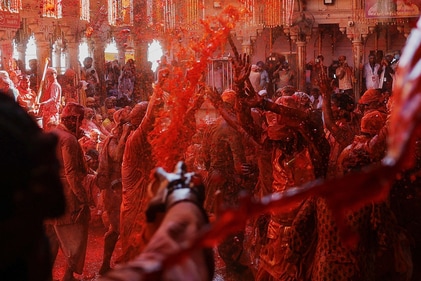 People throw coloured water as they celebrate "Lathmar Holi" inside a temple in the town of Barsana. (Reuters)