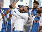 India's Virat Kohli and teammates celebrate with the winners trophy on the podium after defeating New Zealand in the final cricket match of the ICC Champions Trophy at Dubai International Cricket Stadium in Dubai, United Arab Emirates, Sunday, March 9, 2025. (AP Photo/Christopher Pike)
