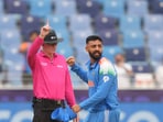 India's bowler Varun Chakravarthy celebrates the wicket of New Zealand's batter Will Young.