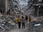 Palestinians walk in a devastated neighbourhood in Beit Lahia in the northern Gaza Strip, ahead of the iftar fast-breaking meal during the Muslim holy month of Ramadan on March 9, 2025. Palestinians walk in a devastated neighbourhood in Beit Lahia in the northern Gaza Strip, ahead of the iftar fast-breaking meal during the Muslim holy month of Ramadan on March 9, 2025.