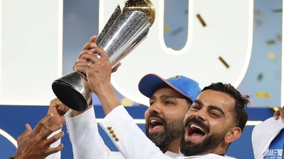 Virat Kohli holds the trophy and celebrates with Rohit Sharma and teammates at the podium. (AP)