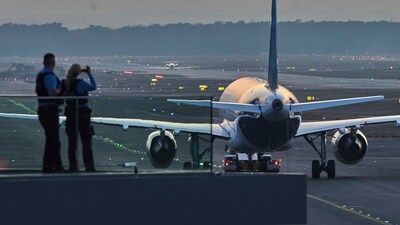 Police officers watch aircrafts take their parking positions at the airport in Frankfurt, Germany, Sunday, March 9, 2025, the evening before a warning strike of all major German airports. (AP) Police officers watch aircrafts take their parking positions at the airport in Frankfurt, Germany, Sunday, March 9, 2025, the evening before a warning strike of all major German airports. (AP)