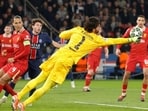 Liverpool goalkeeper Alisson (C) dives to punch the ball during their Champions League match against PSG. Liverpool goalkeeper Alisson (C) dives to punch the ball during their Champions League match against PSG.
