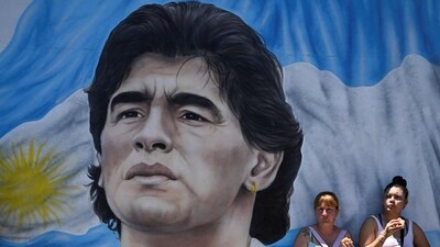 Members of social organizations stand next to a mural depicting late Argentine football star Diego Maradona during a protest at Pueyrredon bridge in Buenos Aires. (AFP) Members of social organizations stand next to a mural depicting late Argentine football star Diego Maradona during a protest at Pueyrredon bridge in Buenos Aires. (AFP)