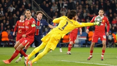 Liverpool goalkeeper Alisson (C) dives to punch the ball during their Champions League match against PSG. (AFP)