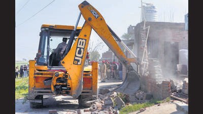 Police demolishing illegal structures of two drug smugglers in Talwandi Kalan village in Ludhiana on Tuesday. (HT Photo)