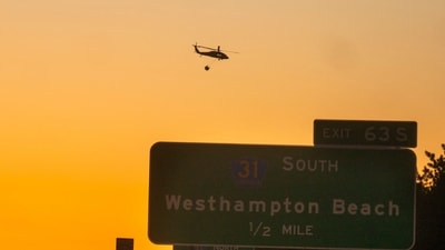 A rescue helicopter carries water along Route 27 on March 8, 2025 in Westhampton, New York. As strong winds fueled multiple brush fires on New York's Long Island, closing roads and reportedly burning structures (Photo by Andrew Theodorakis / GETTY IMAGES NORTH AMERICA / Getty Images via AFP) (Getty Images via AFP) A rescue helicopter carries water along Route 27 on March 8, 2025 in Westhampton, New York. As strong winds fueled multiple brush fires on New York's Long Island, closing roads and reportedly burning structures (Photo by Andrew Theodorakis / GETTY IMAGES NORTH AMERICA / Getty Images via AFP) (Getty Images via AFP)