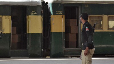 A security force personnel member stands guard near a train containing empty coffins that are dispatched to Bolan where a passenger train that was attacked by separatist militants, at a railway station in Quetta, Pakistan, March 12, 2025. (REUTERS)