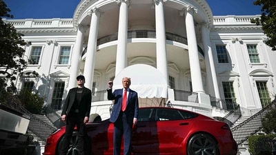 Donald Trump and Tesla CEO Elon Musk speak to the press as they stand next to a Tesla vehicle on the South Portico of the White House. (Mandel NGAN / AFP)