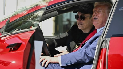 Donald Trump and Elon Musk speak to reporters as they sit in the red Model S Tesla vehicle on the South Lawn of the White House. (AP)