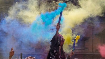 In Kathmandu, people were seen celebrating with Holi with vibrant coloured smoke along with water guns. (Niranjan Shrestha/AP) In Kathmandu, people were seen celebrating with Holi with vibrant coloured smoke along with water guns. (Niranjan Shrestha/AP)