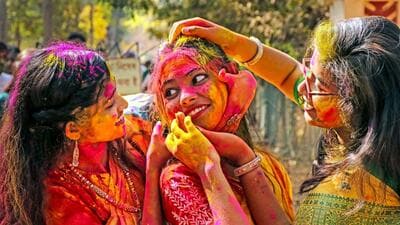 Students of Visva-Bharati University smear colour on each other's faces ahead of Basanta Utsav at Santiniketan in Birbhum district (PTI/ Representative photo)
