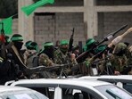 Palestinian Hamas fighters carry their guns in Nuseirat in the central Gaza Strip on February 22, 2025. Palestinian Hamas fighters carry their guns in Nuseirat in the central Gaza Strip on February 22, 2025.