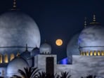 The setting moon is pictured over the Sheikh Zayed Grand Mosque in Abu Dhabi on March 14 , 2025, during the Islam's holy fasting month of Ramadan.
